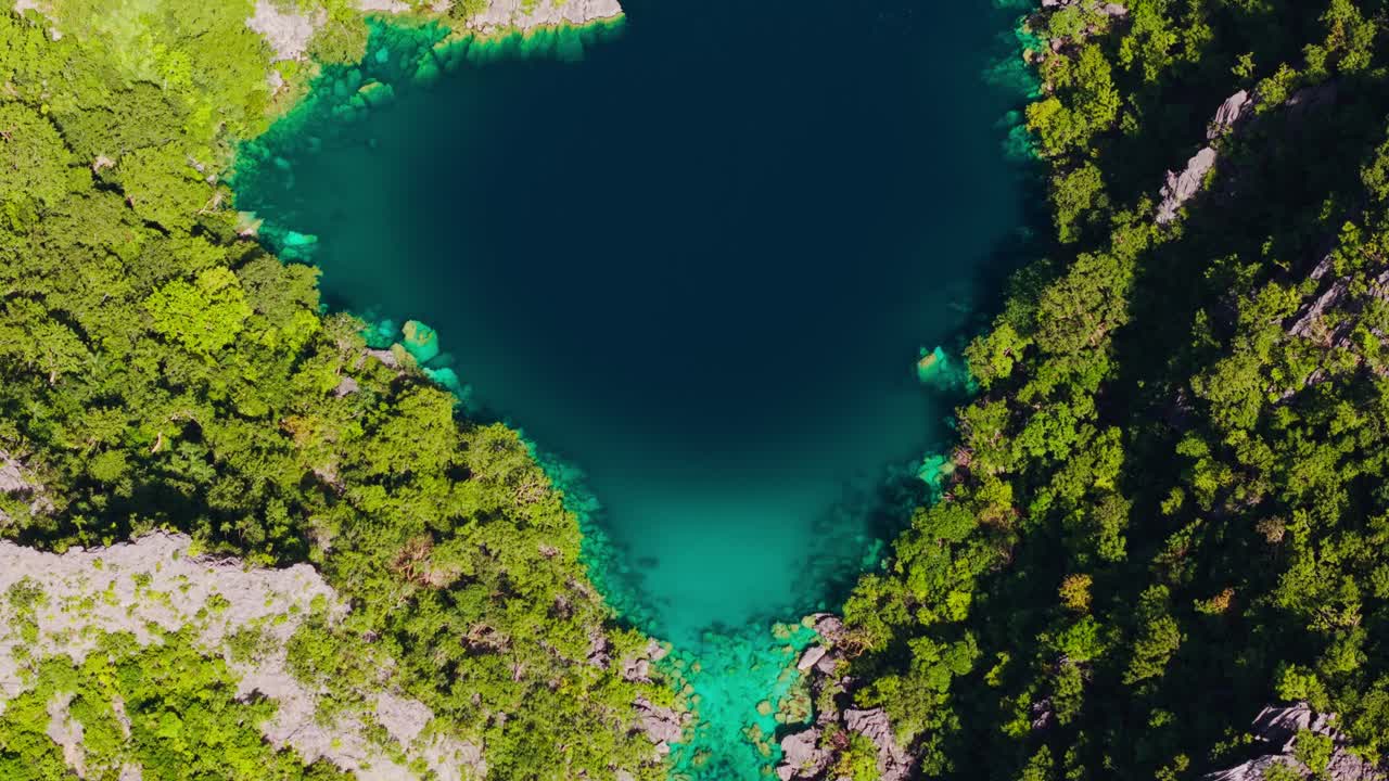 Acque blu vivaci e color smeraldo circondano scogliere calcaree al Lago Kayangan, Coron
