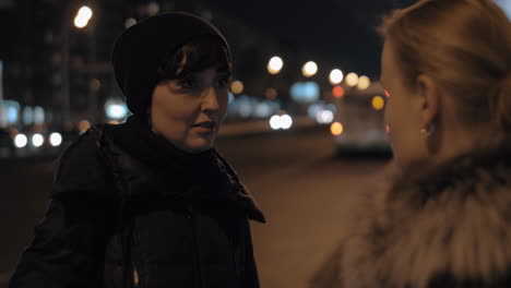 Dos-Mujeres-Hablando-Afuera-En-La-Ciudad-De-Noche