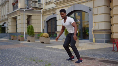 Afro-guy-dancing-latino-dance-on-street.-Male-dancer-making-body-moves-in-city