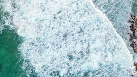 Peaceful-view-of-waves-creating-sea-foam-on-a-clearwater