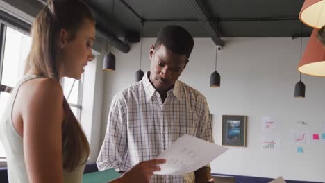 Happy-diverse-business-people-discussing-work-during-meeting-at-office