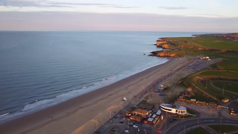 A-descending-drone-shot-of-the-South-Shields-Coastline,-by-the-beach