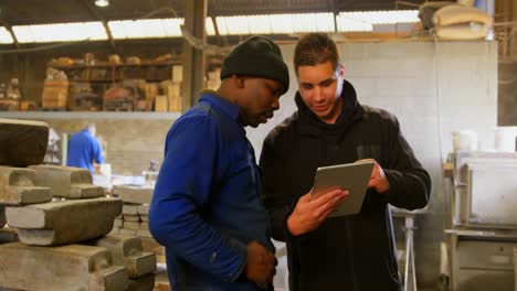 trabajadores discutiendo sobre tableta digital en el taller 4k