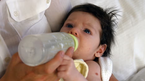 bebé joven bebiendo de una botella de leche