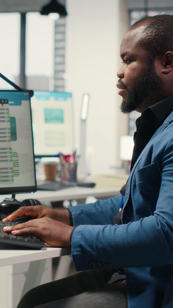 Vertical Video Black male analyst focused on IT company development with digital tools