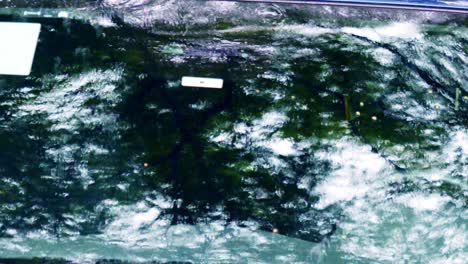 Vehicle-windscreen-reflects-back-rainfall,-wet-season,-Brazil,-South-America