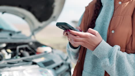 woman using phone with open car hood