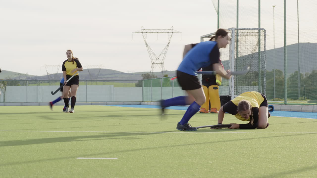 Female hockey player practicing on outdoor field during sunny day