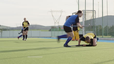 female hockey player practicing on outdoor field during sunny day
