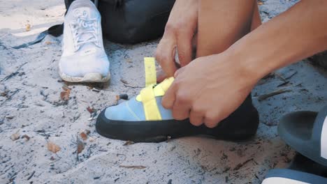 Nahaufnahme-Eines-Teenagers,-Der-In-Seine-Kletterschuhe-Im-Sand-Wechselt