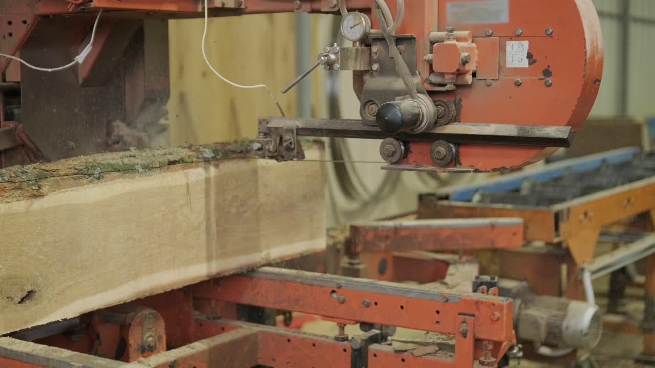Large Wood Log Being Cut by Industrial Band Saw in Sawmill