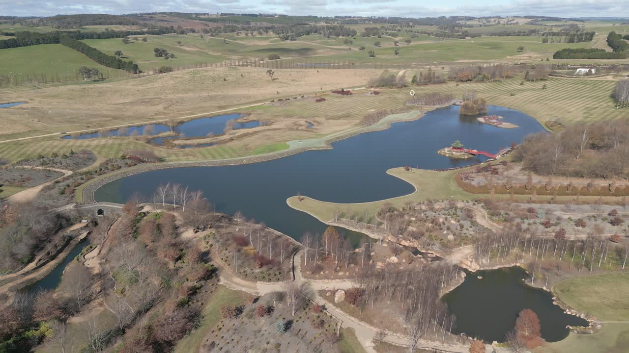 enorme estanque con isla cenador en vivero y jardín cultivado