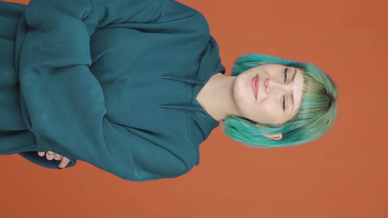 Lodret video af ung kvinde, der smiler til kameraet.