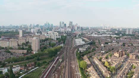 dolly forward drone shot of busy british rail train tracks towards london city centre