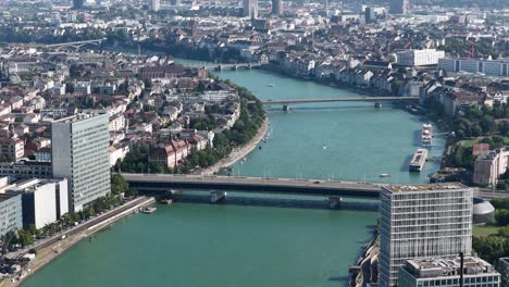 the rhine river running through basel, switzerland, featuring the dreirosenbrucke, railroad, and skyline infrastructure. aerial drone video