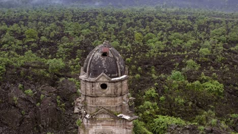 camera rises smoothly revealing the ruined church with lush forest in the background