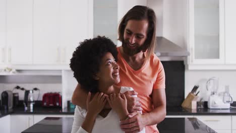 Retrato-De-Una-Pareja-De-Raza-Mixta-Sonriendo-Y-Abrazándose-En-La-Cocina-De-Casa