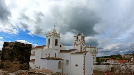 timeless santa maria church tavira portugal a changeable spring day with stormy clouds passing by