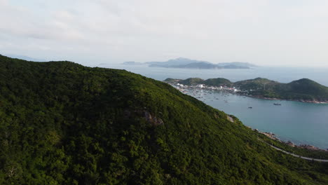 Forsthügel-An-Der-Küste-Vietnams-Mit-Majestätischem-Blick-Auf-Die-Insel-Binh-Hung-Mit-Kleiner-Stadt-Und-Booten