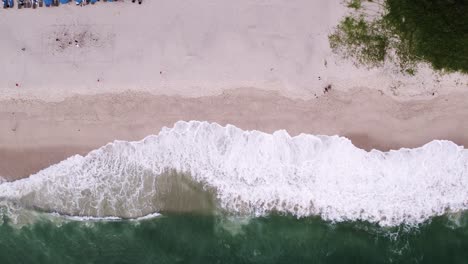 Vista-De-Arriba-Hacia-Abajo-De-Olas-Espumosas-Rompiendo-Sobre-La-Orilla-Arenosa-En-Phuket,-Tailandia