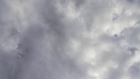 stormy clouds move quickly up and across deep blue skies beyond, time lapse