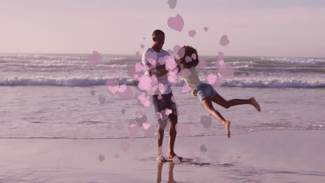 father and daughter playing on beach with pink heart animation overlay