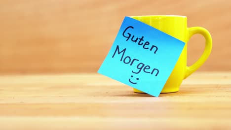 Coffee-cup-with-a-good-morning-in-German-sticky-note