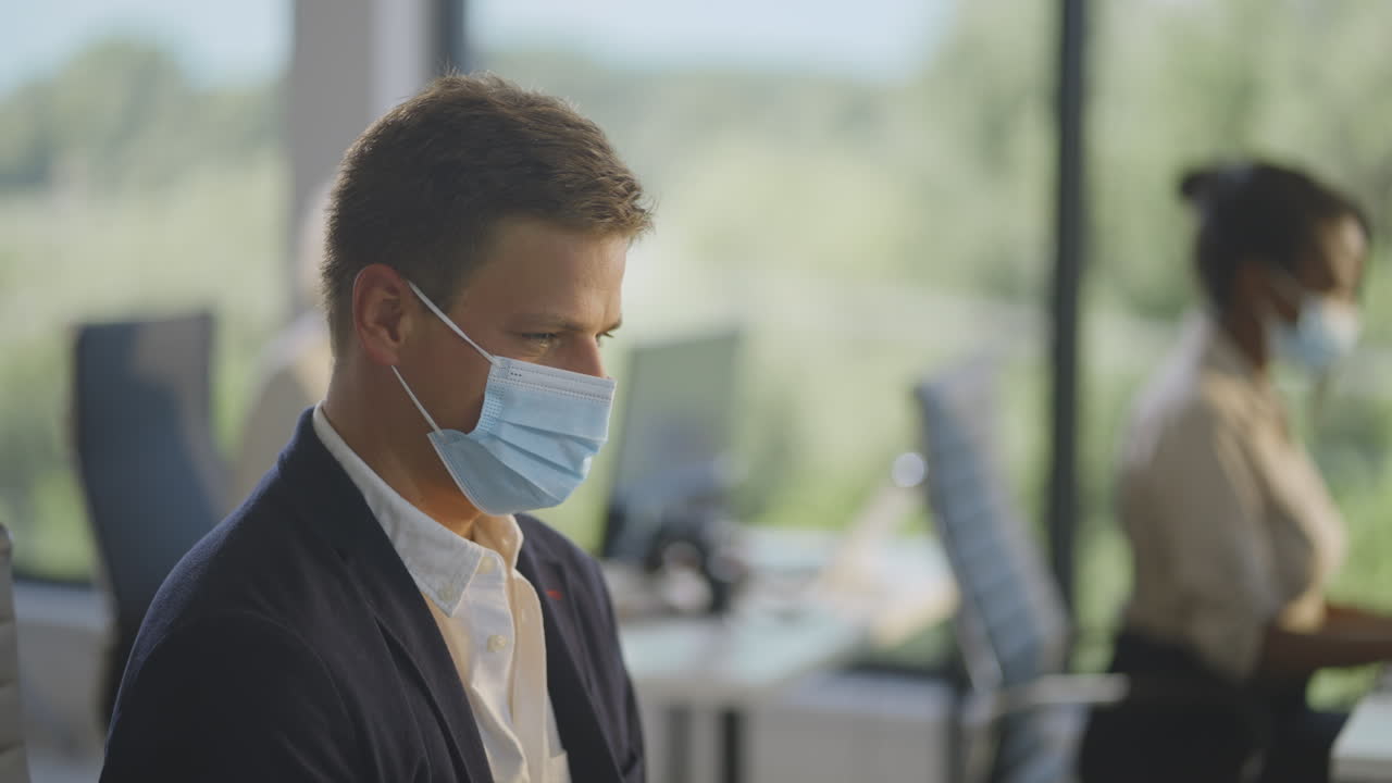 회의 중 마스크를 착용 한 사무실 직원 들