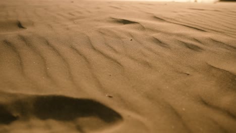 wind blows ripples in sand in slow motion on hot sunny day in the desert or beach