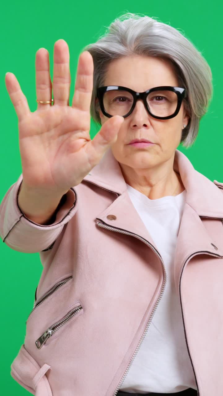 Mature Woman Making Stop Gesture and Shushing on Green Screen