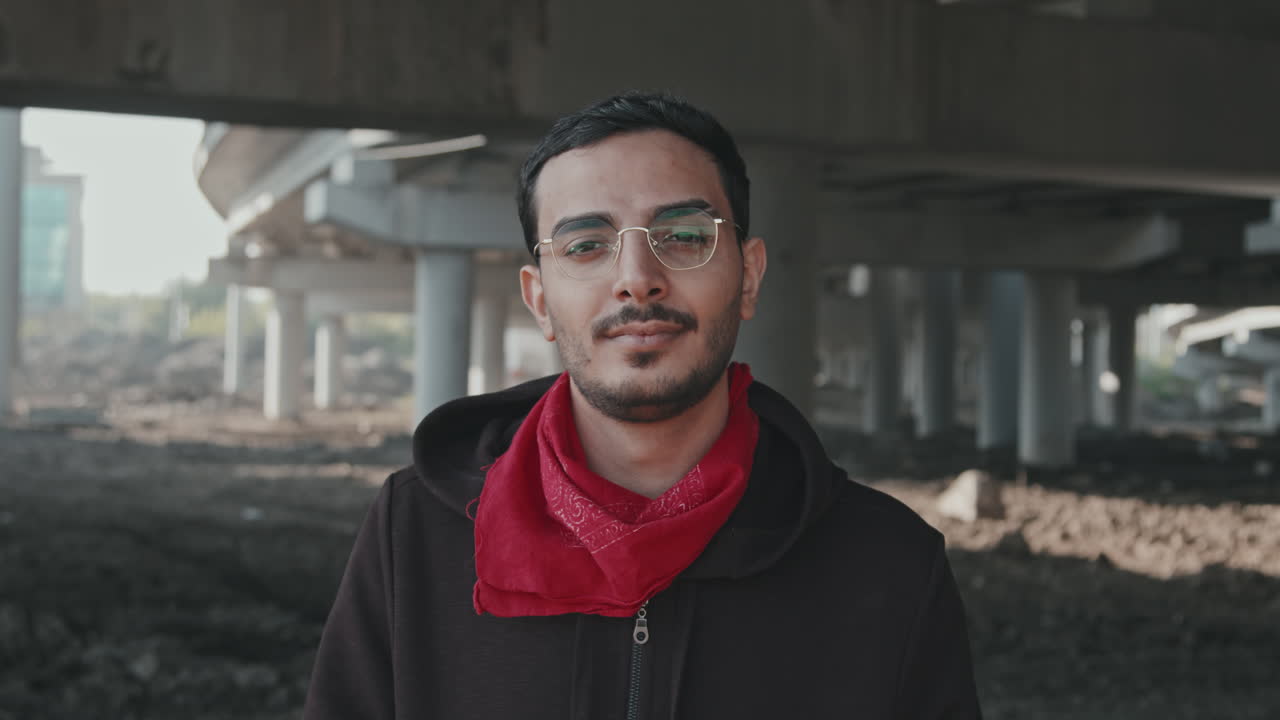 Man with Glasses and Bandana Under Urban Underpass