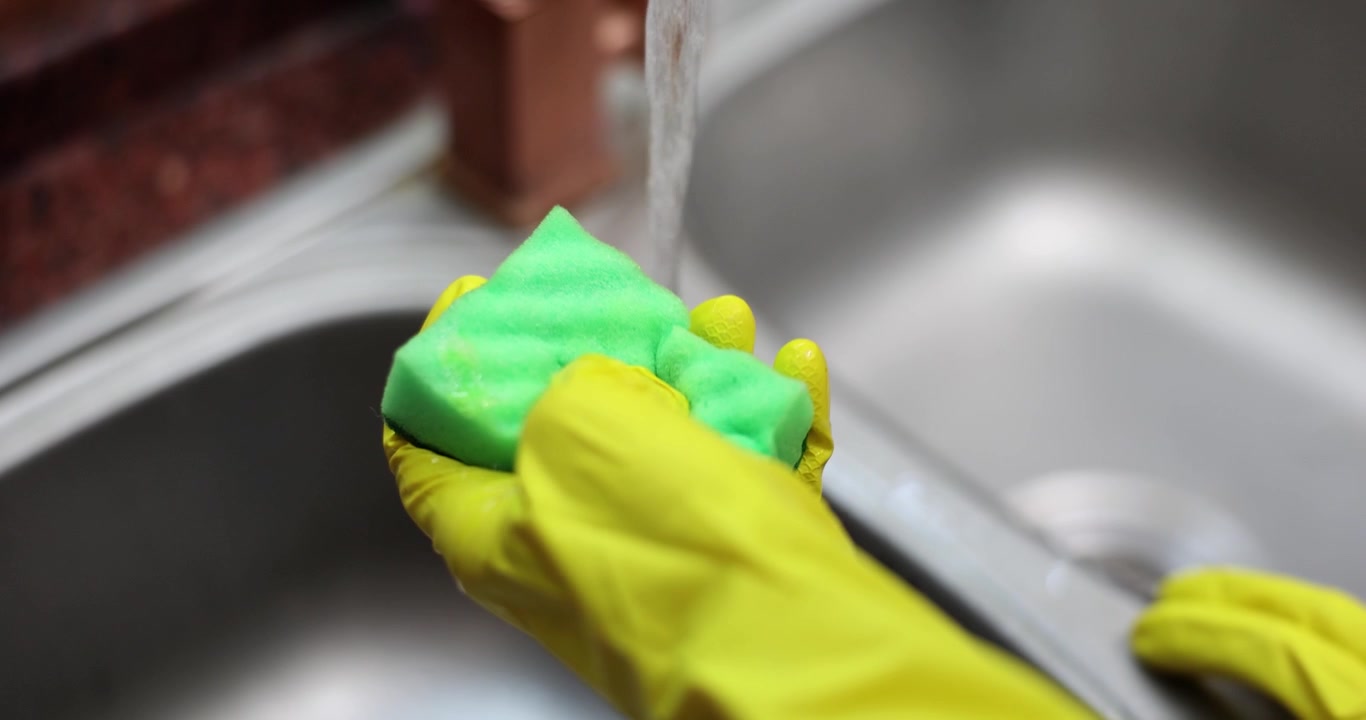 Cleaning the kitchen sink with passion and care in a cozy home