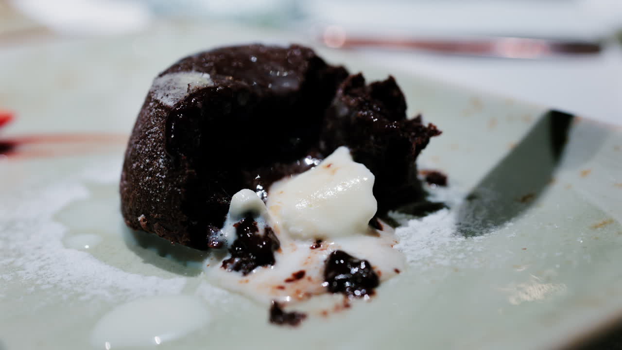 Close up of a rich chocolate lava cake with melted center served with vanilla ice cream