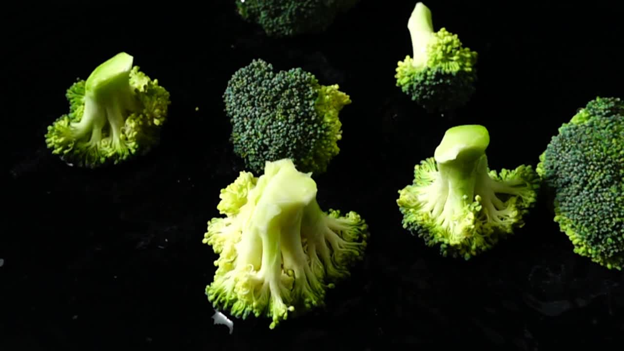 Pezzi di broccoli che cadono al rallentatore