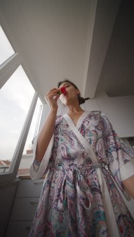 woman eating watermelon in a kitchen