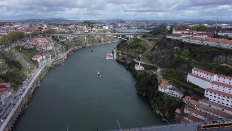 aerial flying backwards over douro river revealing porto city, portugal