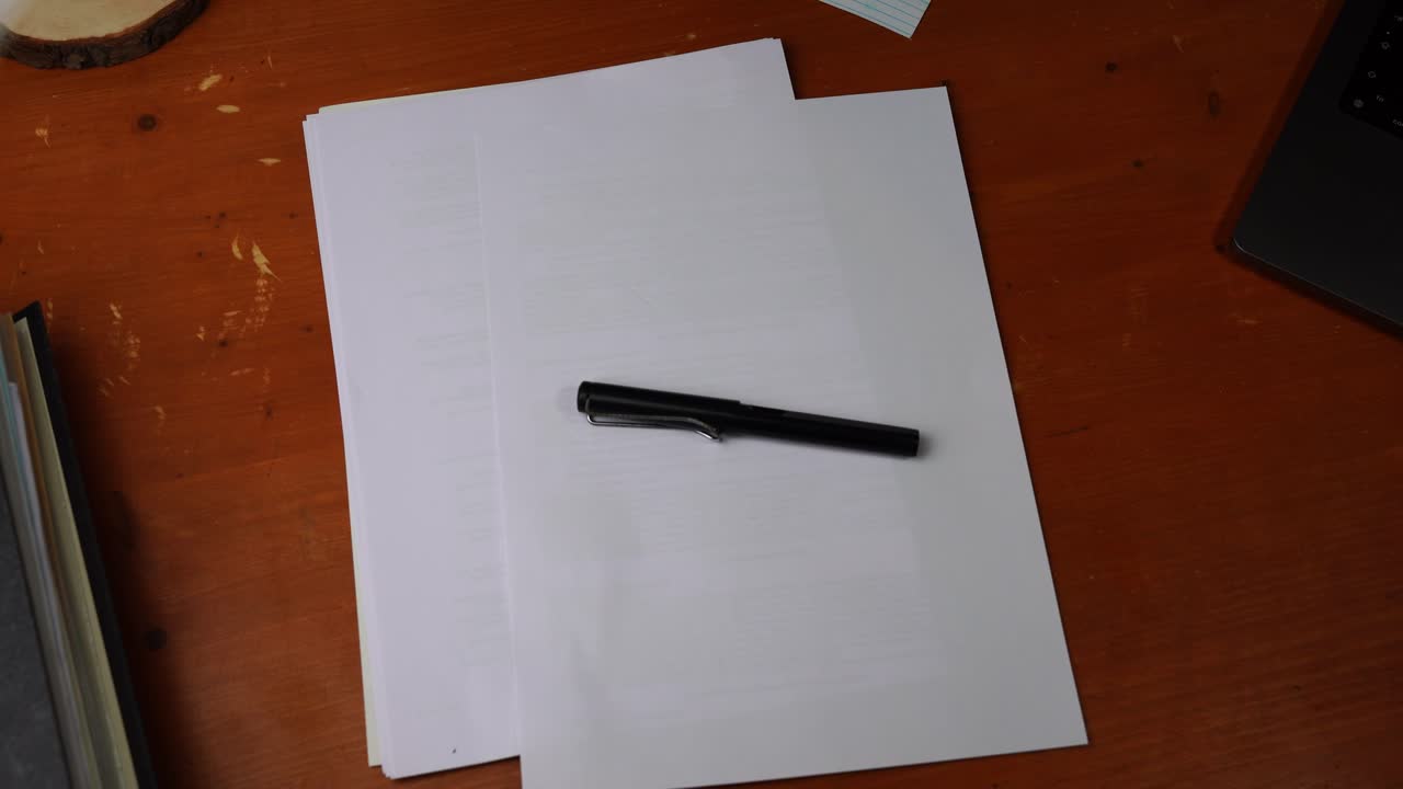 Black abundance is placed on a piece of paper by a hand on a wooden desk and grabbed again and taken away