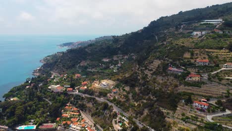 Vista-Aérea-De-La-Riviera-Italiana-Rural-Con-Sus-Caminos-Sinuosos-Y-Filas-De-Viñedos-En-La-Costa-Mediterránea-Montañosa