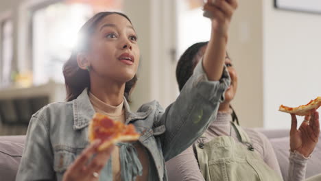 two friends enjoying pizza and watching tv