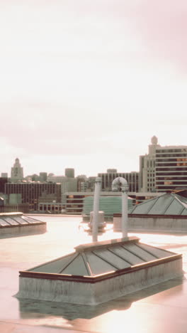 a rooftop view of a city skyline with the sun setting in the background