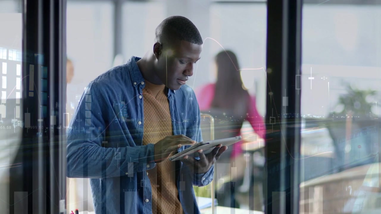 Man tapping tablet near glass partition, activating moving candlestick charts for finance analysis