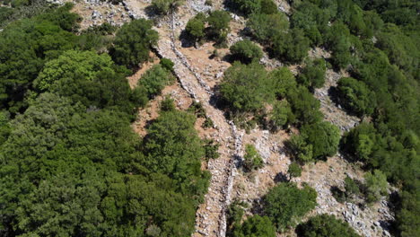 Sendero-Rocoso-A-Las-Ruinas-De-La-Fortaleza-Askifou-Con-árboles-Verdes-En-Pendiente-En-Grecia