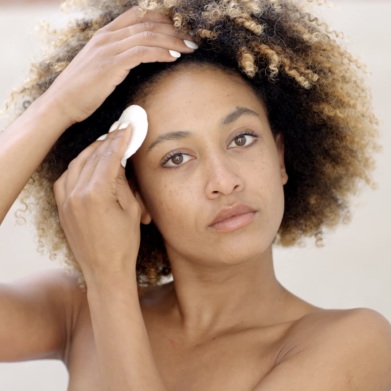 mujer joven limpiando la piel