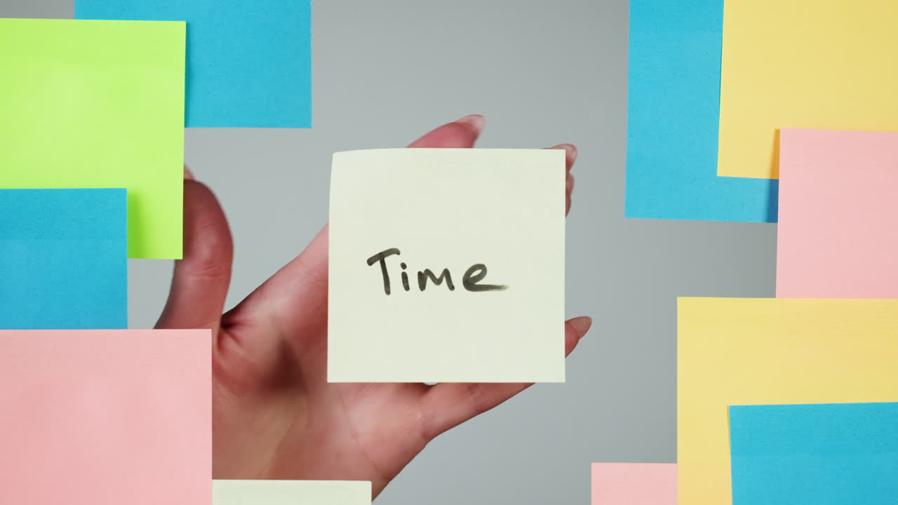 Hand Placing "Time" Sticky Note on Gray Background with Colorful Notes