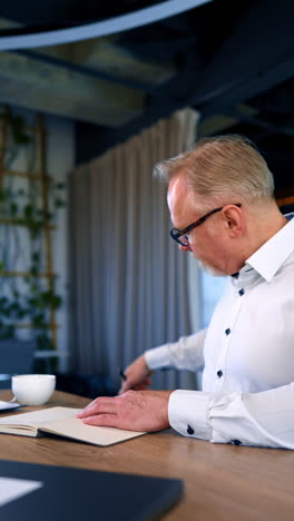 serious handsome manager in the office. mature successful businessman. vertical video.