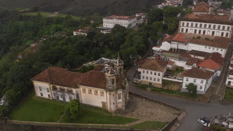 aerial view of saint francis of assisi church in ouro preto, minas gerais, brazil, revealing the city centre with tourist fair and central tiradentes square early in the morning with empty streets