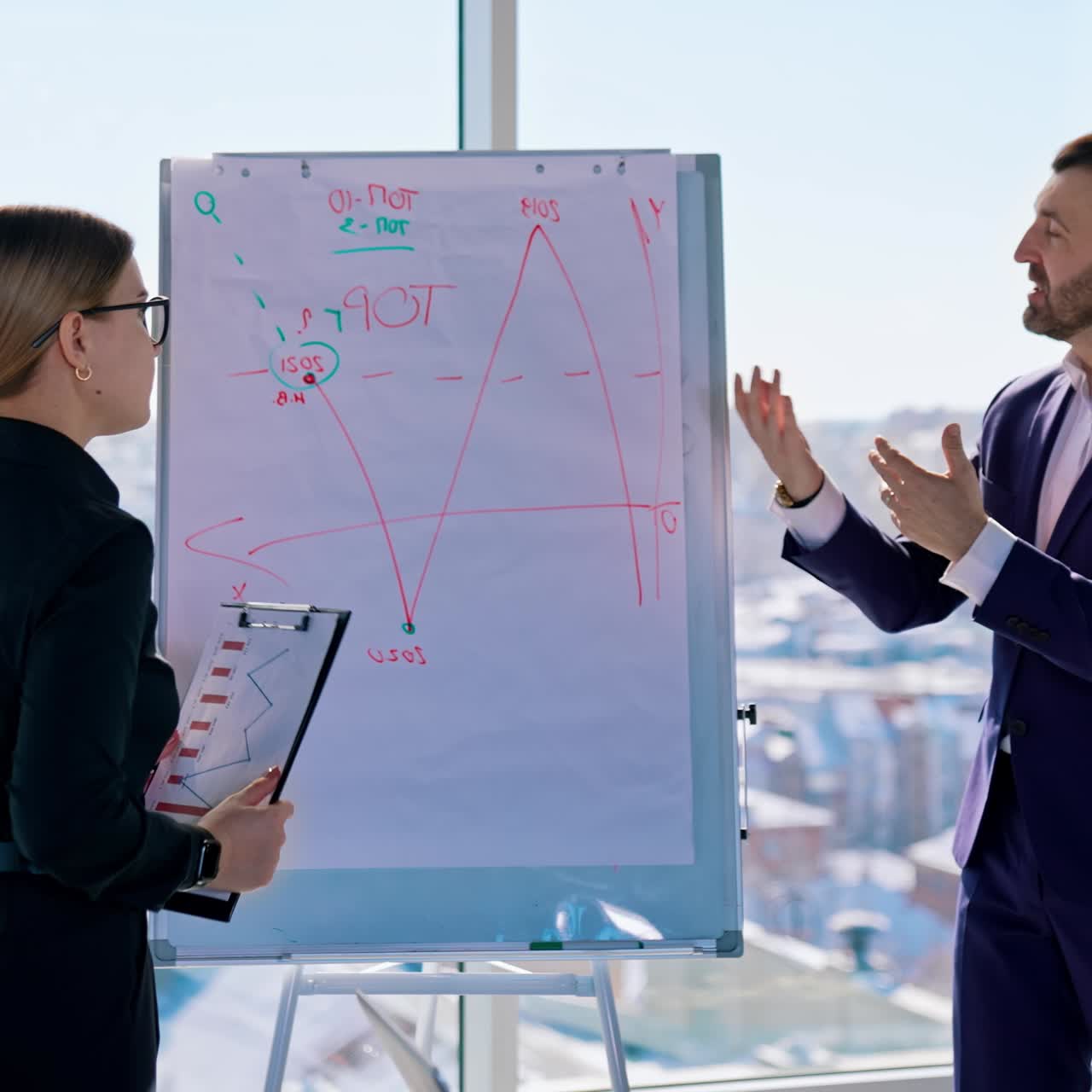 Group of business workers indoors. Young entrepreneurs develop the new business plan while standing near the white board on window background with city view
