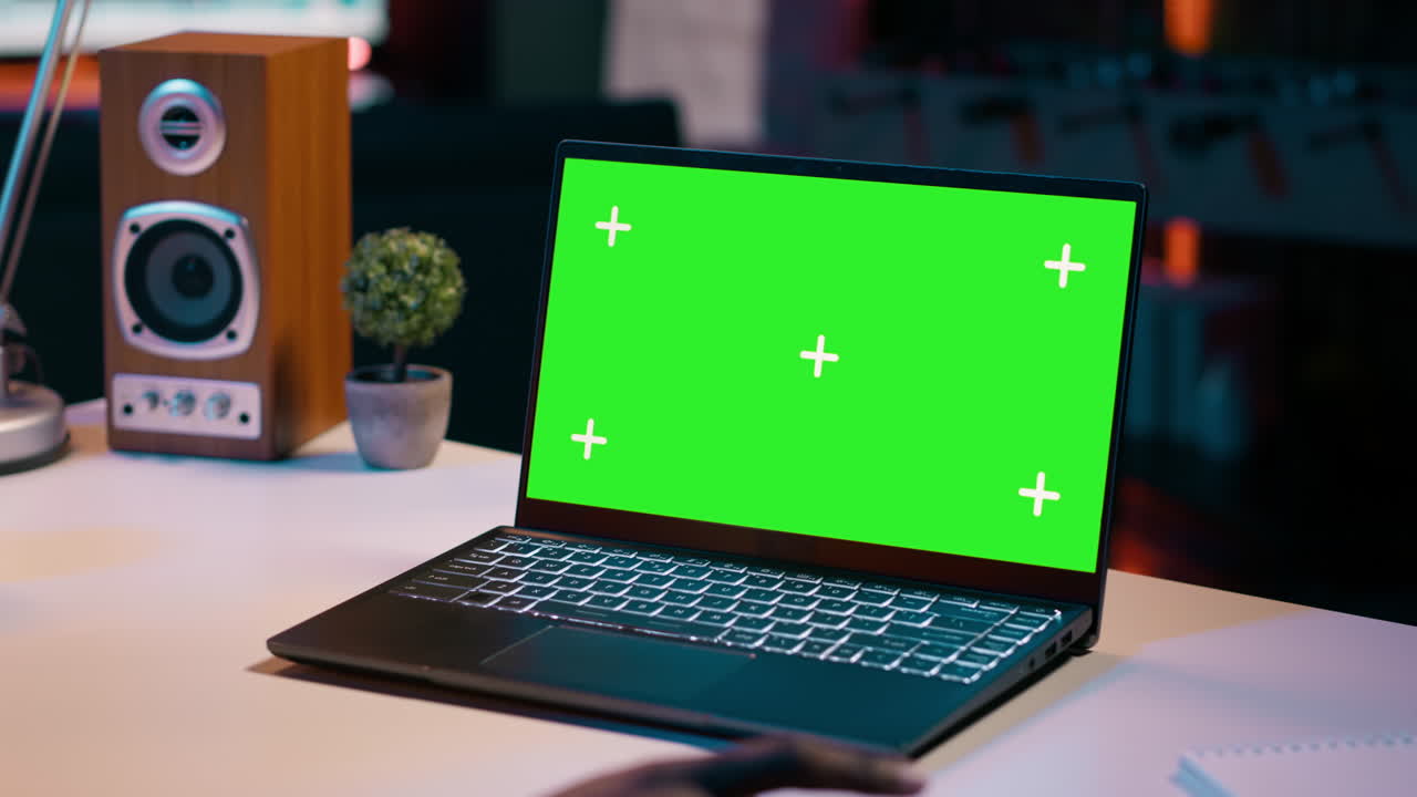 University student checks greenscreen display on laptop at home