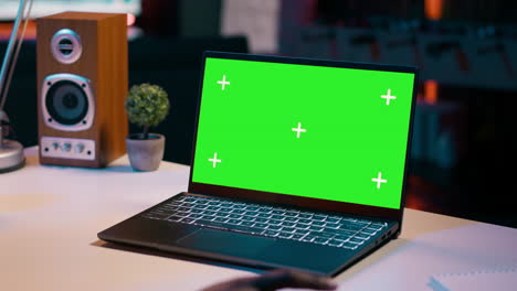 University student checks greenscreen display on laptop at home