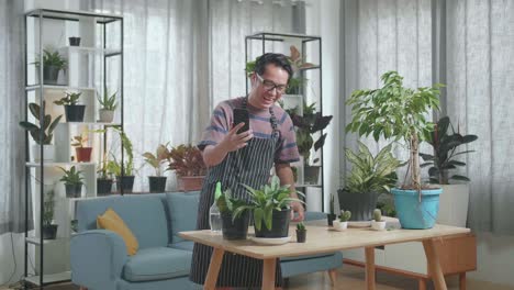 hombre haciendo una llamada de video mientras cuida de sus plantas de interior